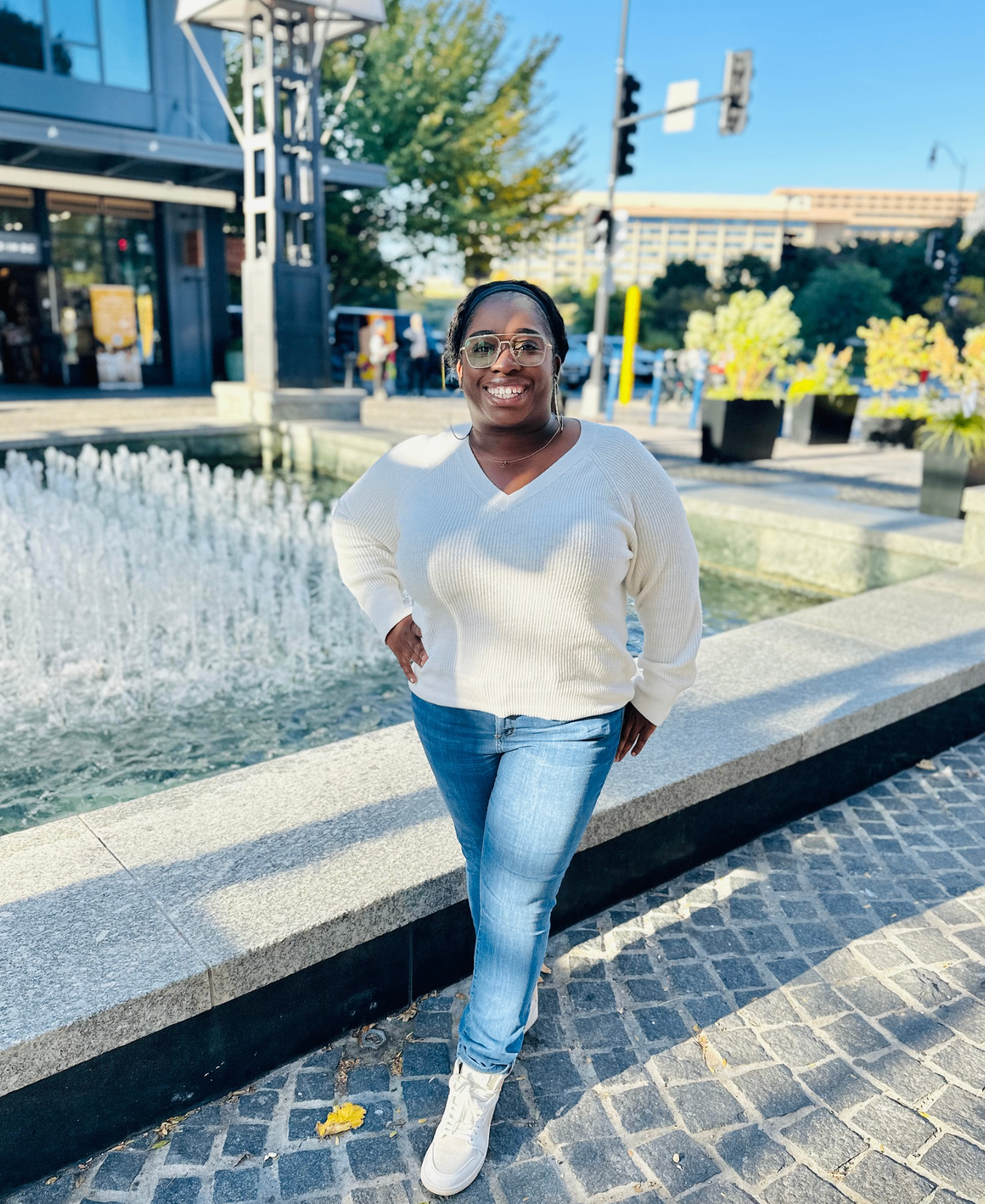 Founder Audrey standing by a fountain, smiling